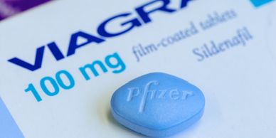 Close-up of a blue Viagra pill and its packaging.