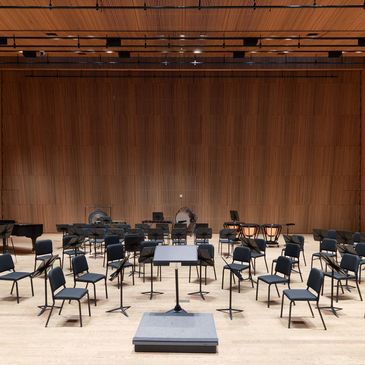 Empty orchestra stage with chairs and music stands.