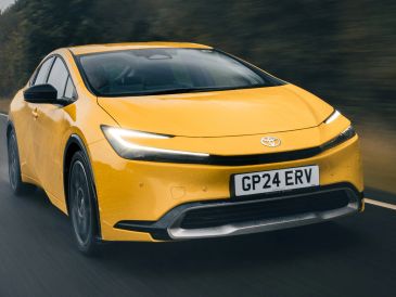 Yellow Toyota car driving on a wet road.
