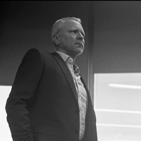 Black and white portrait of a serious man in a suit looking away.