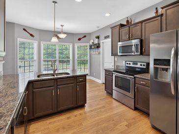 Modern kitchen with dark wood cabinets and stainless steel appliances.