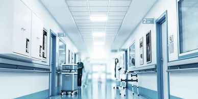 Bright, clean hospital corridor with medical equipment and staff.