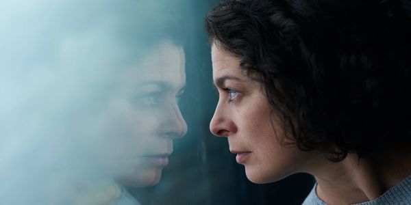 Woman staring out a window looking anxious and uneasy