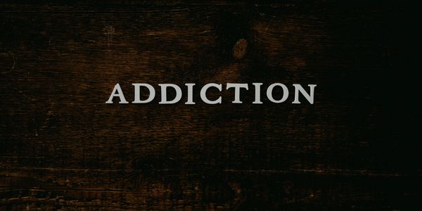 Image of white letters spelling out Addiction against a dark brown background