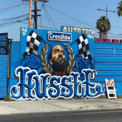 Mural of Nipsey Hussle with checkered flags and Crenshaw sign.