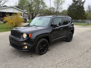 Black Jeep Renegade parked on a residential street.