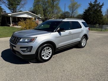 Silver SUV parked on a residential street on a sunny day.