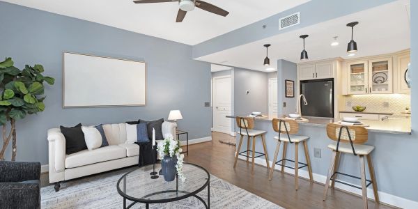 Modern living room with blue walls and a kitchen bar with wooden stools.