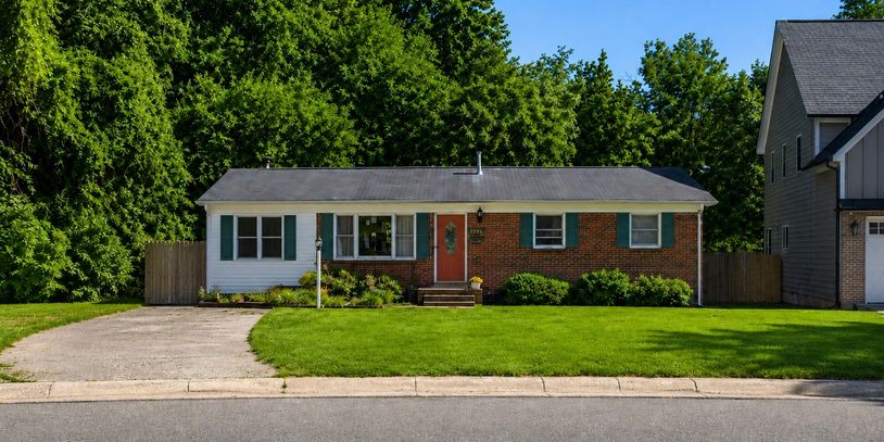 Single-story suburban house with brick and white siding exterior and a green lawn.