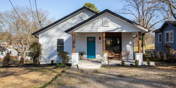 Cozy white house with a bright blue door and a small front porch.