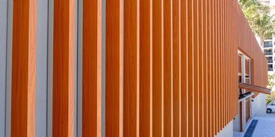 Modern building facade with vertical wooden slats and concrete walls.