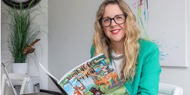 Woman reading a colorful children's book.