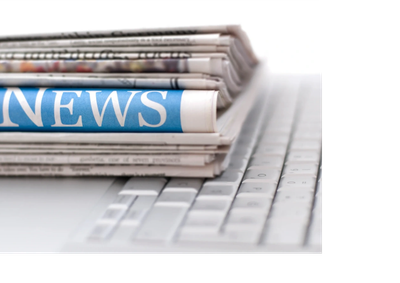 Stack of newspapers on a computer keyboard.