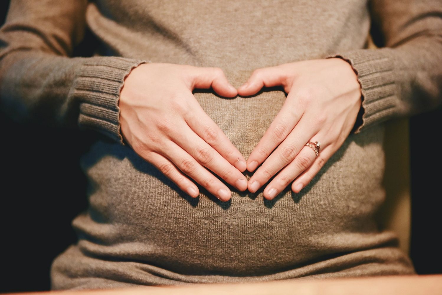 Pregnant woman forming a heart over her belly