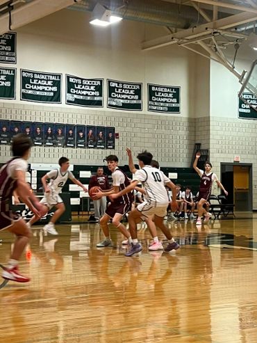 High school basketball game with players in action on the court.