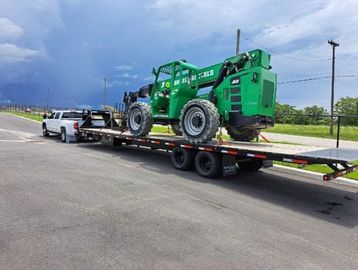 long tow truck towing a farm equipment