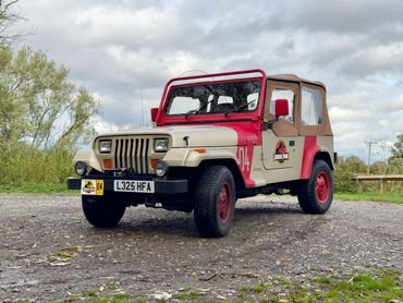 JP04 Jurassic Park Jeep parked outdoors on gravel with soft top roof