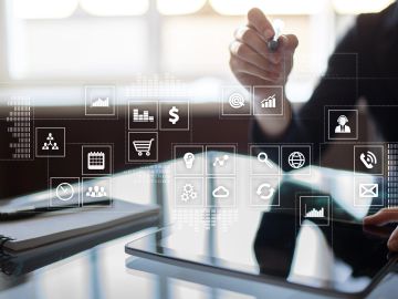 Hand interacting with a digital tablet surrounded by business icons.