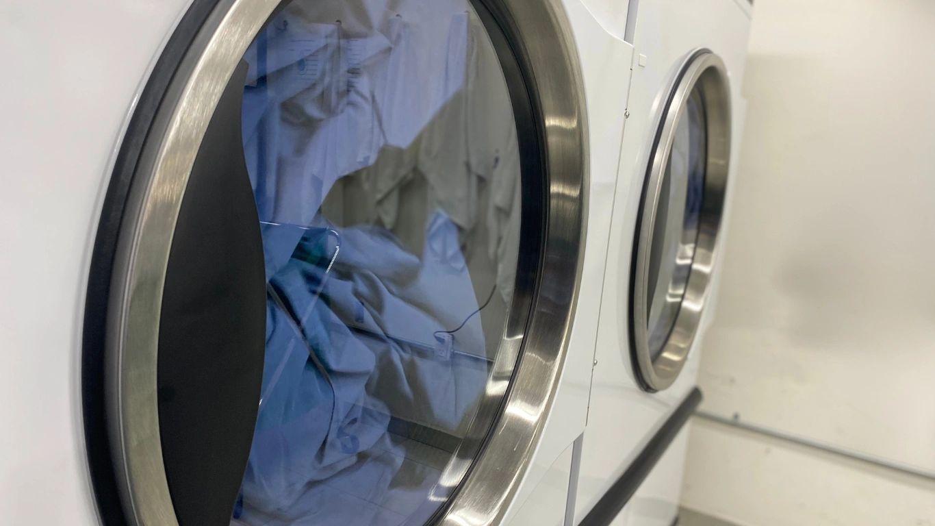Two front-loading washing machines with laundry inside.