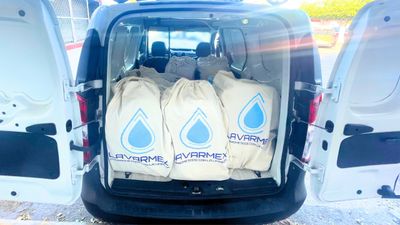 Open van with large bags labeled Lavarme inside.
