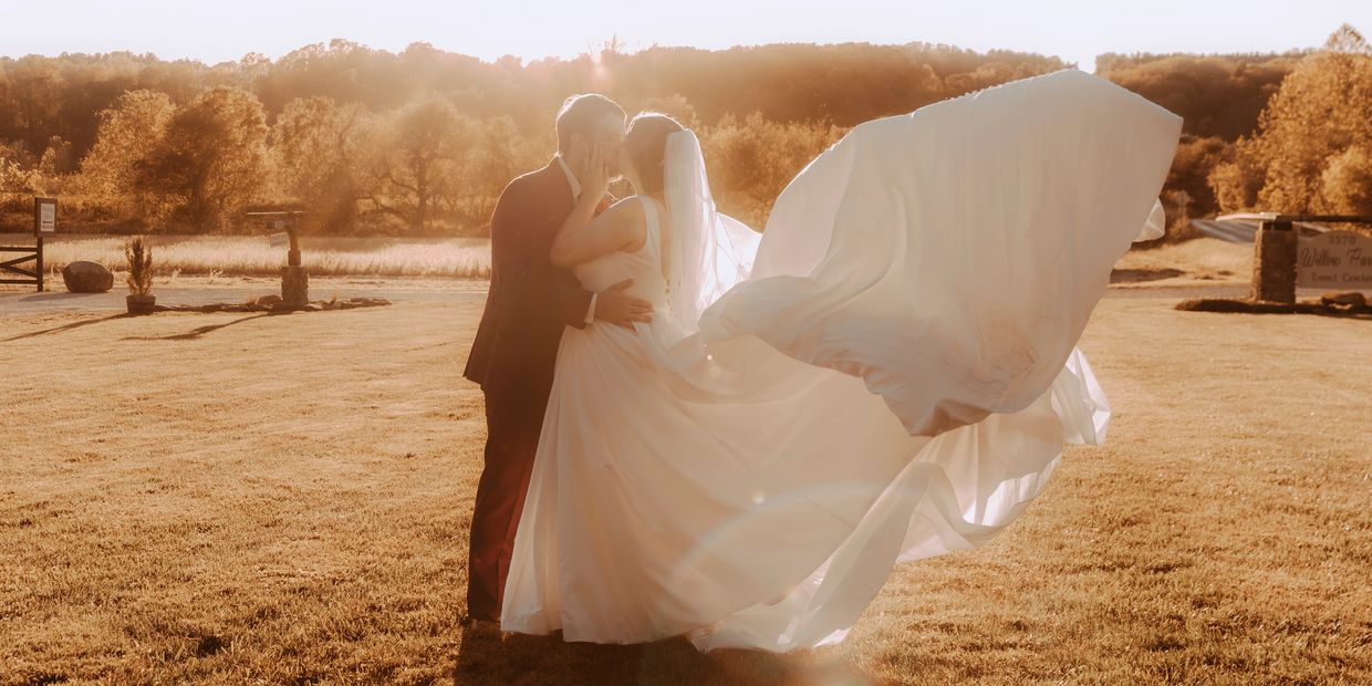 Couple kissing during sunset on their wedding day.