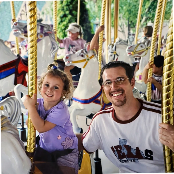 Justin Yellott on a carousel with his daughter Mia