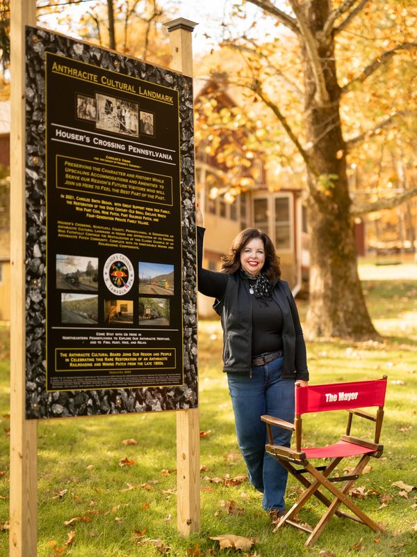 carolee posing next to the cultural landmark sign on the property