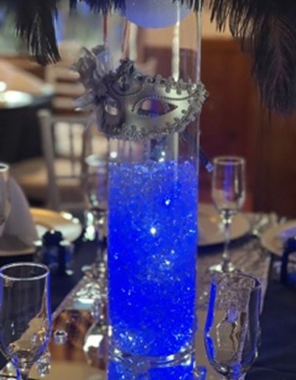 Elegant blue centerpiece with a masquerade mask for a formal event.