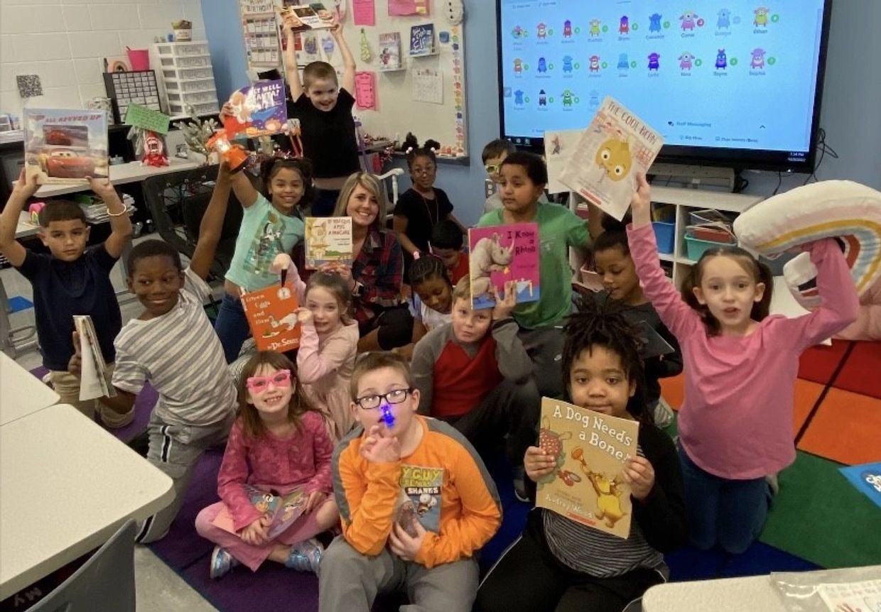 Elementary school class holding up books