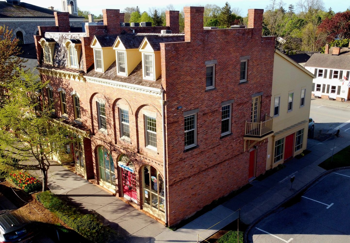 Historic brick building with distinctive chimneys and red doors on a sunny day.