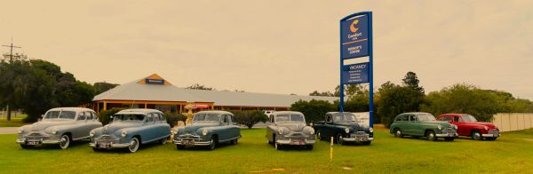 Vintage cars lined up outside a Comfort Inn motel.