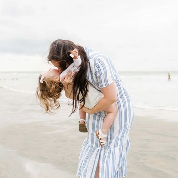 mother daughter kisses on the beach