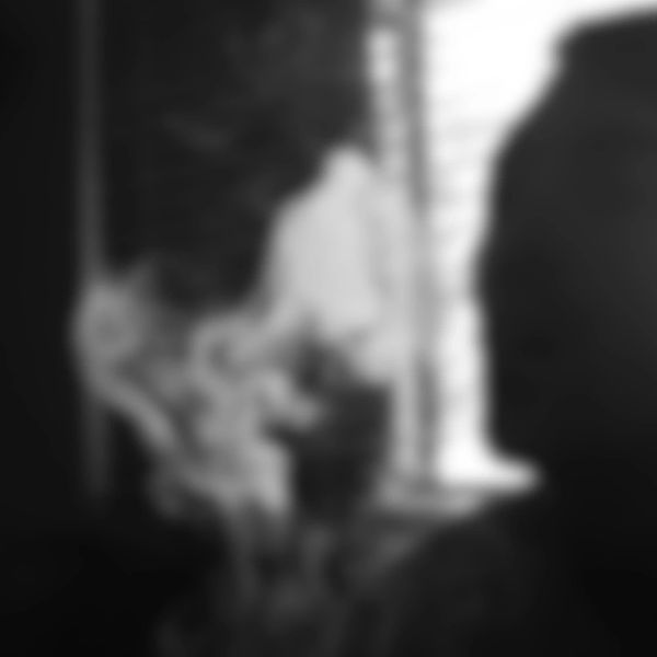 Blurry black and white image of people near a window.