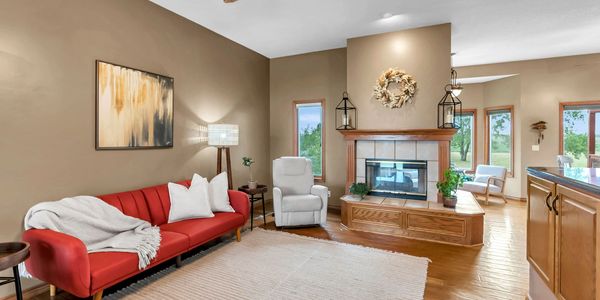 Cozy living room with red sofa and fireplace.