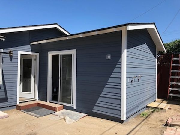 Room addition in with sliding glass door and  blue matching siding
