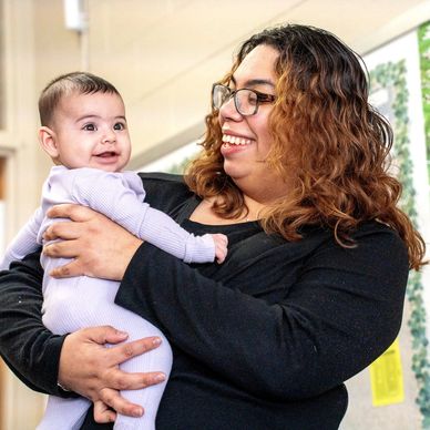 Infant teacher holding baby