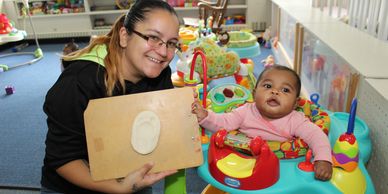 Infant Teacher creating a footprint ornament.