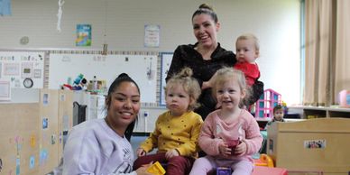 Teacher and assistant with three children in Pre-Toddler Room.