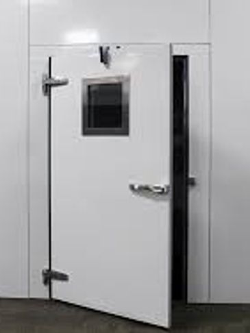 White industrial door with a small window, slightly open.