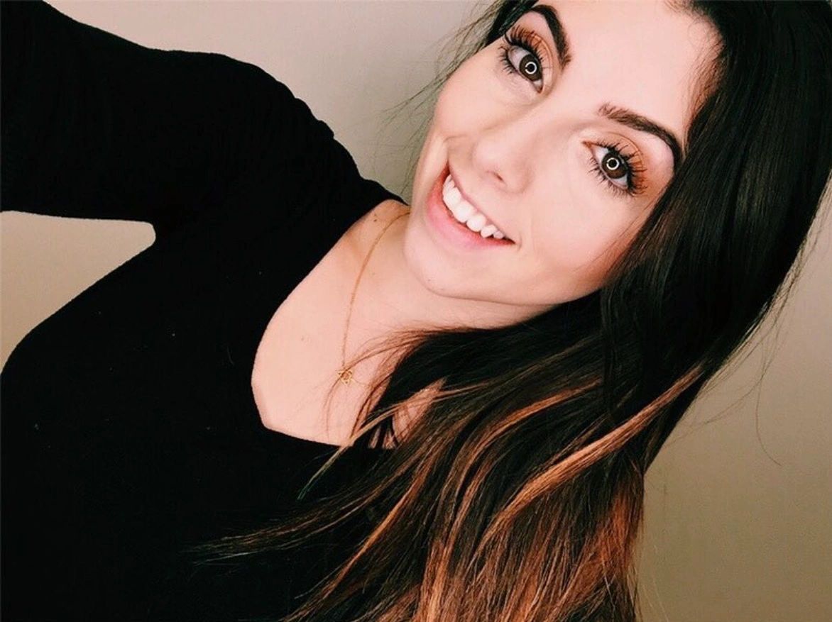 Smiling woman with long hair and a black top.