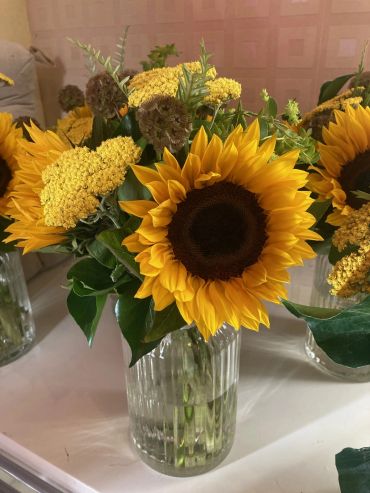 Bright sunflowers in a glass vase.