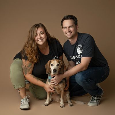 Woman and man posing with beagle