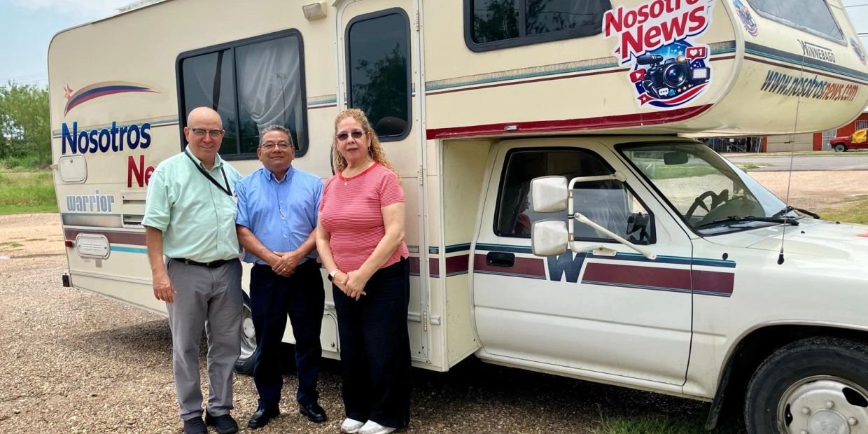 Tres personas junto a una casa rodante de Nosotros News.