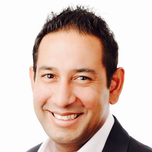 Smiling man in business attire with a white background.
