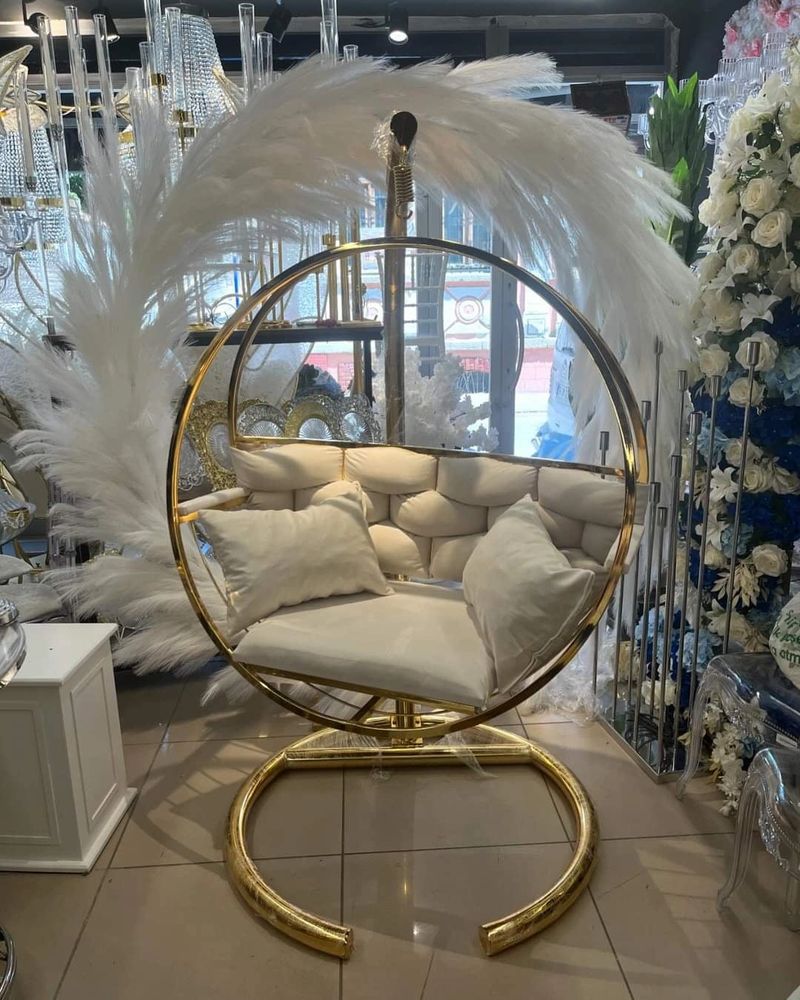 Kayzia Gold Swing Chair is sleek, Featuring a Gold frame and plush Cream cushions