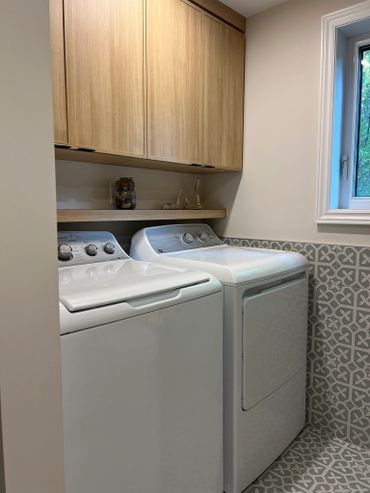 Modern laundry room with washer, dryer, and patterned tiles.
