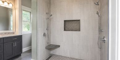 Large modern walk-in shower with bench and dual showerheads.