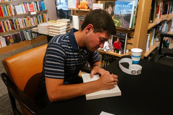 Man signing a book at a bookstore.