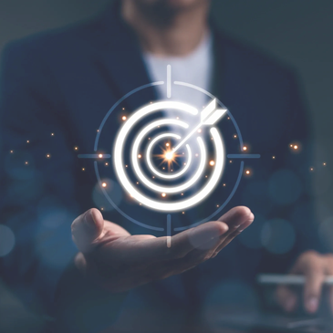 Businessman holding a glowing target with an arrow hitting the center.