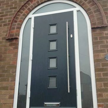Arched Solid Core composite door in Anthracite Grey with a Long Bar handle fitted in Forest Town.